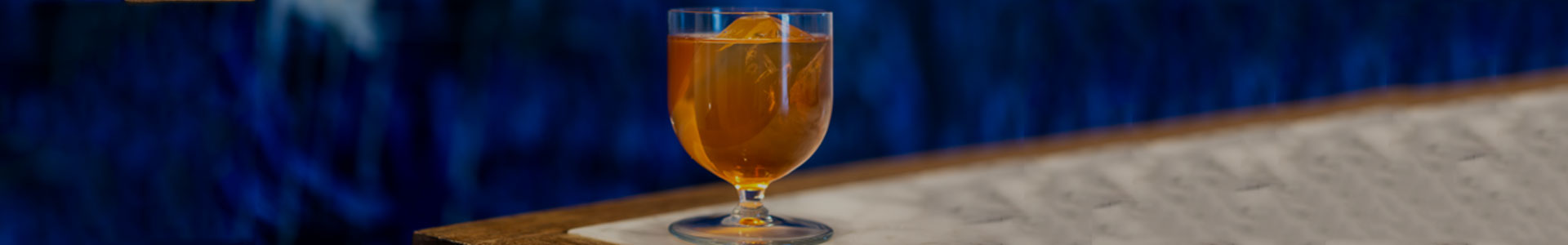 Libbey Levitas Cocktailglas mit orangenem Drink auf einem Tisch.