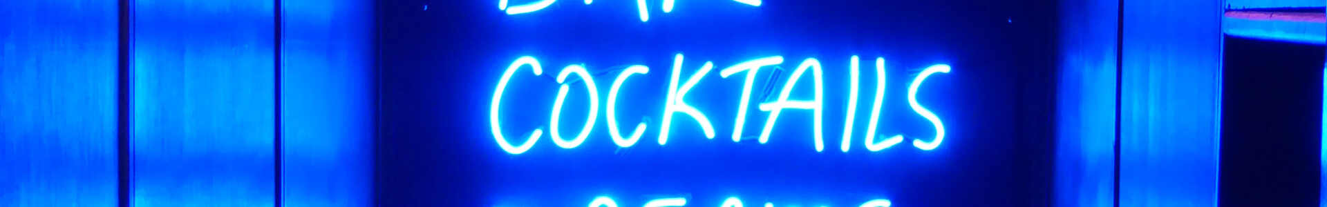 Blaues Neon-Schild mit den Wörtern Bar, Cocktails, Dreams, Disco.