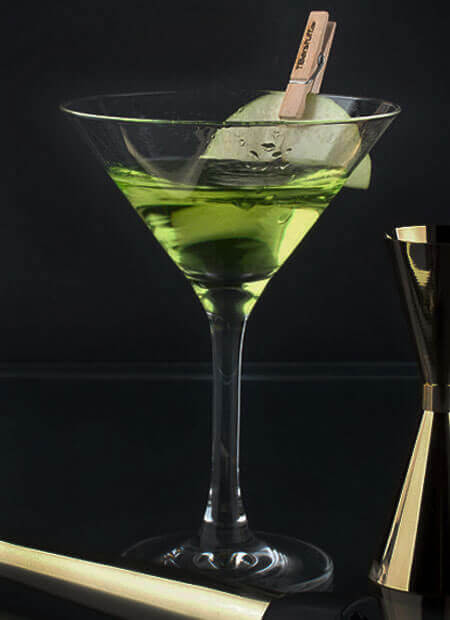 Typisches Martini-Glas mit spitzem Kelch, gefüllt mit einem grünen Drink.