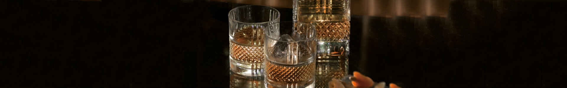 Whiskykaraffe und Gläser aus der Serie Brillante von RCR stehen auf einem Tisch.